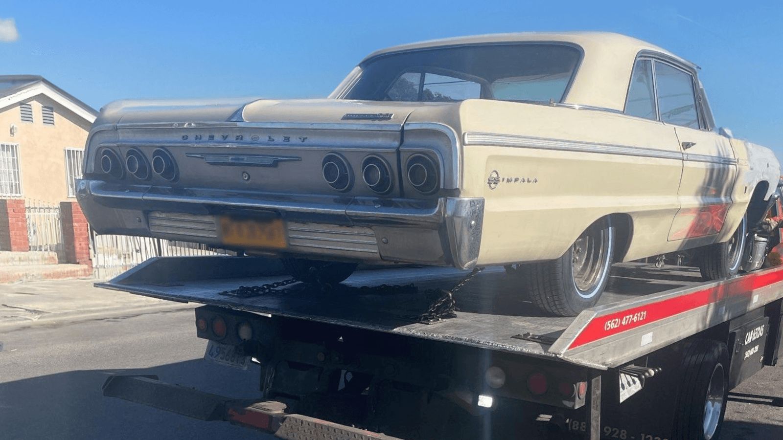 A classic Chevrolet Impala strapped on a Carsaad Towing flatbed in Norwalk, CA